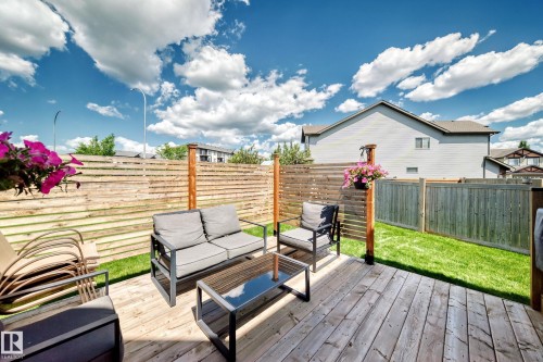 Spacious wood-finish deck with horizontal slat fencing and a manicured lawn - 13724 166 Avenue Nw, Edmonton, AB 