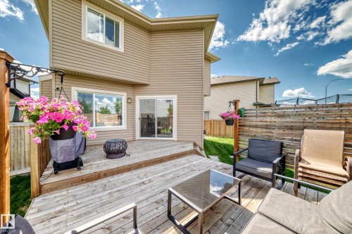 Spacious wood deck with a privacy fence, sliding glass patio door, and a grass lawn - 13724 166 Avenue Nw, Edmonton, AB 