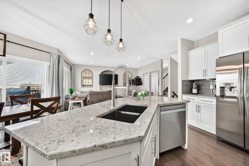 Expansive kitchen island featuring a deep undermount sink and a gooseneck faucet, complemented by light-toned countertops - 13724 166 Avenue Nw, Edmonton, AB 