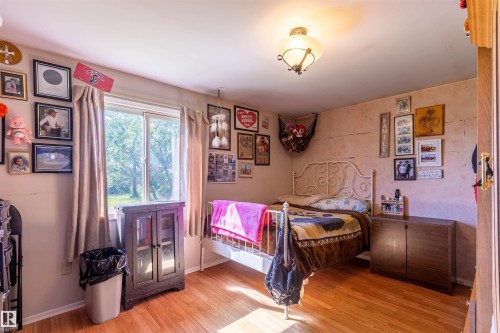 Bedroom featuring wood-finish flooring, a double-paned window, and an overhead semi-flush mount light fixture - 551027 Range Road 193, Rural Lamont County, AB 