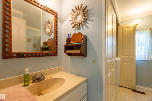 Bathroom vanity featuring an integrated sink, dual-handle faucet, and an ornate framed mirror - 551027 Range Road 193, Rural Lamont County, AB 