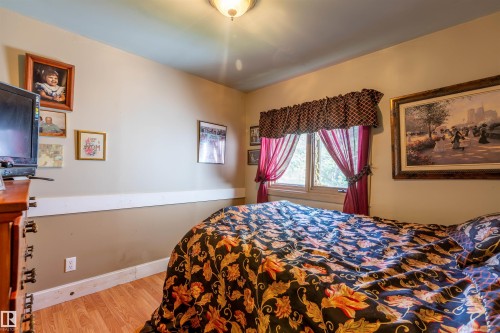 Bedroom featuring wood-finish flooring, a wall-mounted light fixture, and a window providing natural light - 551027 Range Road 193, Rural Lamont County, AB 
