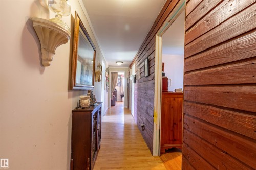 Hallway featuring wood-finish flooring, recessed lighting, and a prominent wood-paneled wall - 551027 Range Road 193, Rural Lamont County, AB 