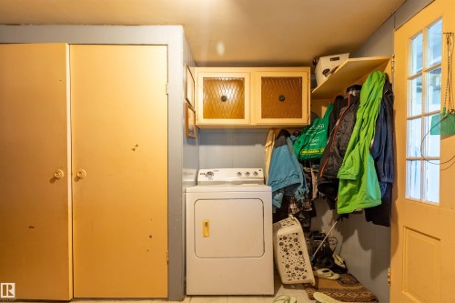 Utility area featuring a built-in shelf, two storage closets, and overhead cabinetry with frosted glass inserts - 551027 Range Road 193, Rural Lamont County, AB 