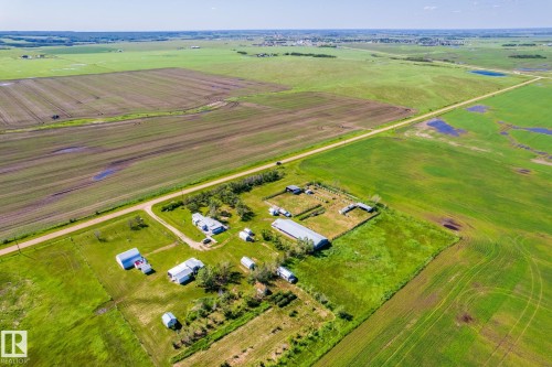 Expansive agricultural property featuring multiple structures, cultivated fields, verdant pastureland, and a gravel road - 551027 Range Road 193, Rural Lamont County, AB 