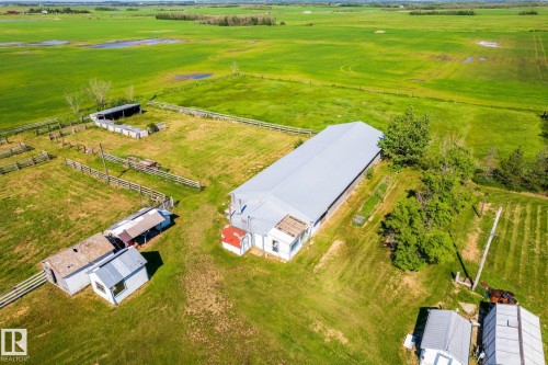 Expansive green acreage featuring a large agricultural building with a metal roof, multiple fenced enclosures, and several outbuildings - 551027 Range Road 193, Rural Lamont County, AB 