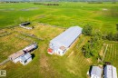 Expansive green acreage featuring a large agricultural building with a metal roof, multiple fenced enclosures, and several outbuildings - 551027 Range Road 193, Rural Lamont County, AB 
