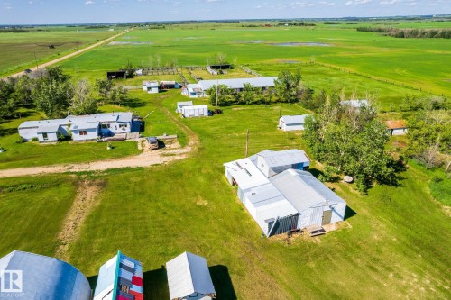 Aerial perspective showcasing multiple outbuildings and structures amidst expansive green fields - 551027 Range Road 193, Rural Lamont County, AB 