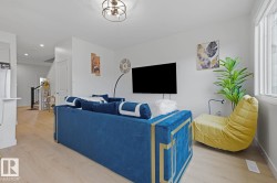Bright living space featuring light wood-finish flooring, white walls, and a recessed lighting - 