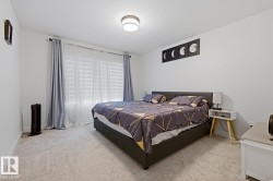 Bright bedroom featuring light-colored carpeting and white walls - 