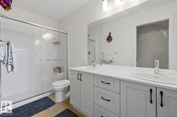 Double vanity with undermount sinks and light-toned countertop, set against wood-finish flooring - 