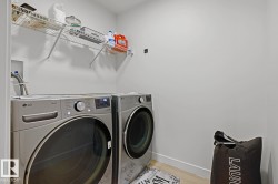 Dedicated laundry area featuring a washer and dryer, convenient wire shelving, and light-toned flooring - 