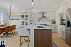 Kitchen with a center island featuring a double-basin sink and a gooseneck faucet - 