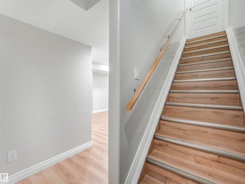 Wood-finish staircase with light wood handrail - 20507 99 Avenue, Edmonton, AB - Indoor Photo Showing Other Room