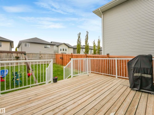 Wood deck with white railing, featuring a lower lawn area and wood privacy fencing - 20507 99 Avenue, Edmonton, AB - Outdoor With Deck Patio Veranda With Exterior