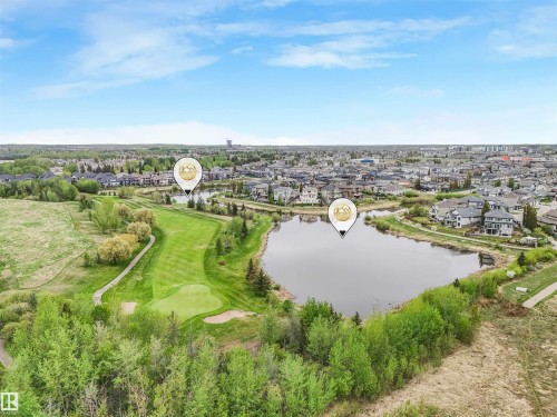 Expansive aerial perspective showcasing a golf course, a serene pond, and residential properties - 20507 99 Avenue, Edmonton, AB - Outdoor With View