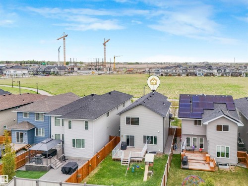Rear exterior featuring a two-story design with light gray siding, a dark shingle roof, and multiple windows - 20507 99 Avenue, Edmonton, AB - Outdoor
