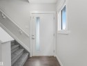 Entryway featuring a white door with a frosted glass insert, wood-finish flooring, a carpeted staircase with white handrail, and a window with white trim - 20507 99 Avenue, Edmonton, AB  - Indoor Photo Showing Other Room 