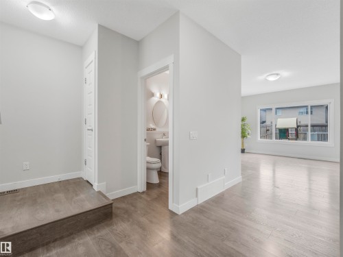 Open-concept living space with wood-finish flooring, recessed lighting, and a prominent window - 20507 99 Avenue, Edmonton, AB - Indoor Photo Showing Other Room