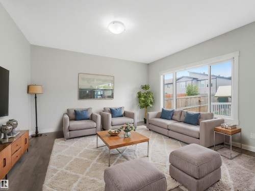 Spacious interior featuring wood-finish flooring, light gray wall tones, and a large window providing ample natural light - 20507 99 Avenue, Edmonton, AB - Indoor Photo Showing Living Room