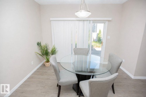 Interior dining area featuring light neutral wall paint and wood-finish flooring - 8 Meadowlink Common, Spruce Grove, AB 