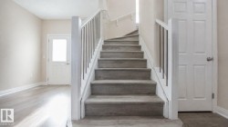 Curved staircase with wood-finish treads and risers, white balusters, and a matching handrail - 
