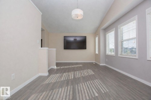 Spacious interior with contemporary wood-finish flooring, multiple windows with horizontal blinds, and a neutral color palette - 8 Meadowlink Common, Spruce Grove, AB 