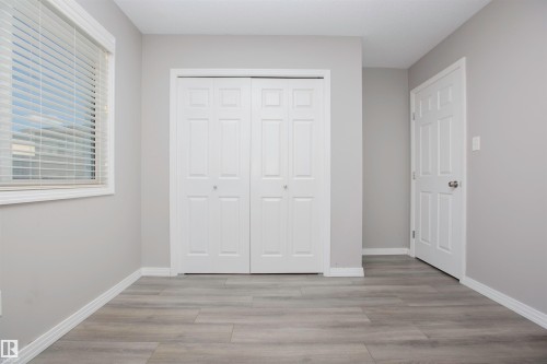 Interior space featuring wood-finish flooring, light grey wall paint, and white trim - 8 Meadowlink Common, Spruce Grove, AB 