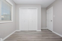 Interior space featuring wood-finish flooring, light grey wall paint, and white trim - 