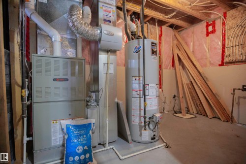Basement area featuring a furnace unit, water heater, visible ductwork, and exposed ceiling joists - 8 Meadowlink Common, Spruce Grove, AB 