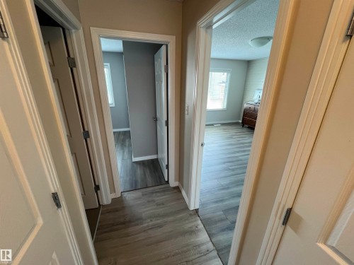 Wood-finish flooring throughout, complemented by light neutral wall tones and white trim - 8 Meadowlink Common, Spruce Grove, AB - Indoor Photo Showing Other Room