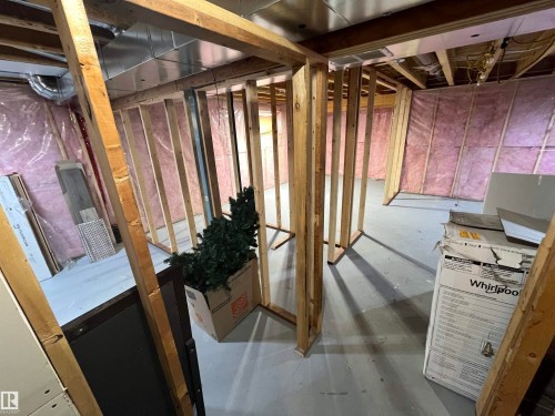 Unfinished basement area featuring framed wall structures, exposed insulation, open ceiling joists, and concrete flooring - 8 Meadowlink Common, Spruce Grove, AB - Indoor Photo Showing Basement