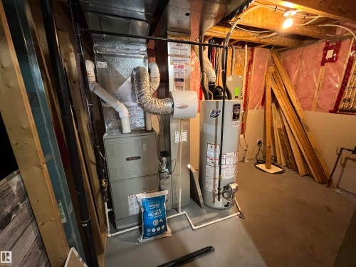Mechanical area featuring a furnace and water heater with exposed ductwork and plumbing - 8 Meadowlink Common, Spruce Grove, AB - Indoor Photo Showing Basement