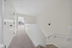 Upper hallway featuring light-colored carpeting, white walls, and recessed lighting - 