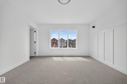 Bright room featuring a three-panel window, wall paneling, and carpet flooring - 