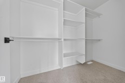 Built-in closet organization system featuring white shelving and clothing rods - 