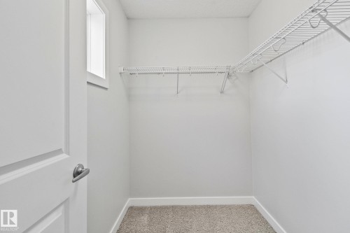 Walk-in closet with wire shelving system, light neutral walls, and window for natural light - 614 Mcdonough Link, Edmonton, AB 