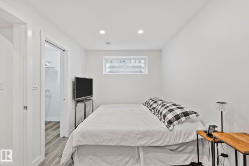 Bright room featuring recessed lighting, a window with blinds, wood-finish flooring, and a sliding door leading to a walk-in closet - 614 Mcdonough Link, Edmonton, AB 