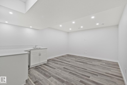 Wet bar featuring a built-in sink, white cabinetry, and a light-toned countertop - 614 Mcdonough Link, Edmonton, AB 