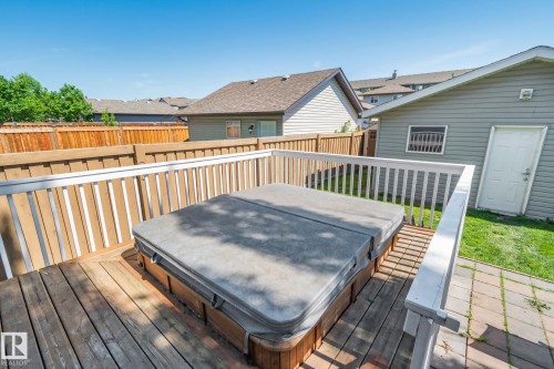 Expansive wooden deck featuring a built-in hot tub with a cover - 614 Mcdonough Link, Edmonton, AB 