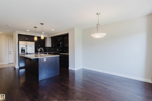Open-concept living area featuring rich wood-finish flooring - 1131 177 Street, Edmonton, AB 