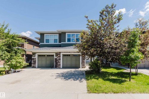 Contemporary multi-level exterior featuring dark green siding and stone veneer accents - 1131 177 Street, Edmonton, AB 
