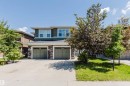Contemporary multi-level exterior featuring dark green siding and stone veneer accents - 1131 177 Street, Edmonton, AB 