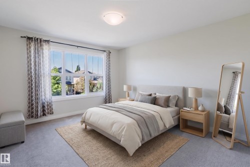 Spacious bedroom featuring light gray carpeting, a large multipane window, and a flush-mount ceiling light - 1131 177 Street, Edmonton, AB 
