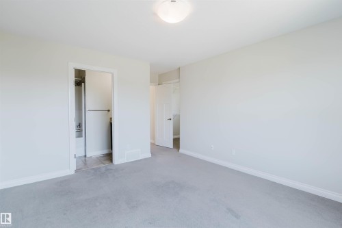 Carpeted room featuring a white ceiling, light-toned walls, and white baseboards - 1131 177 Street, Edmonton, AB 