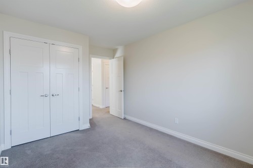 Neutral-toned interior room with gray carpet flooring and white baseboards - 1131 177 Street, Edmonton, AB 