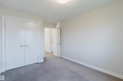Neutral-toned interior room with gray carpet flooring and white baseboards - 