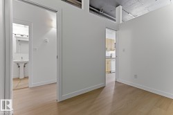 Light wood-finish flooring extending throughout, complemented by white walls and trim - 