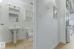 White pedestal sink with a rectangular mirror and white vanity light fixture - 