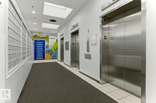 Mailbox wall paneling, multiple stainless steel elevators, recessed lighting, and skylights - 404 10024 Jasper Avenue, Edmonton, AB 